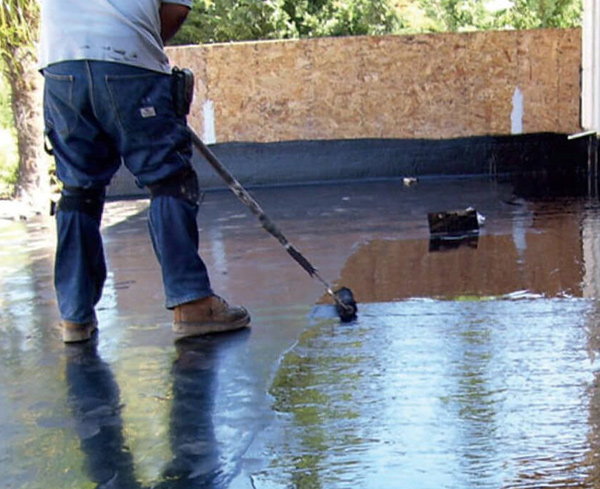 Contractor waterproofing a roof