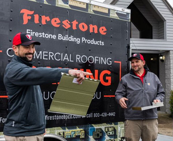 Two employees standing in front of a Firestone truck